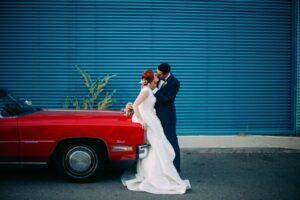 fotografía de boda con un coche clásico rojo