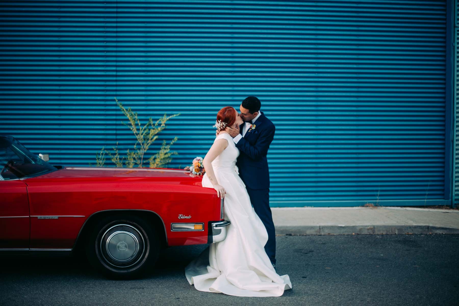 fotografía de boda con un coche clásico rojo
