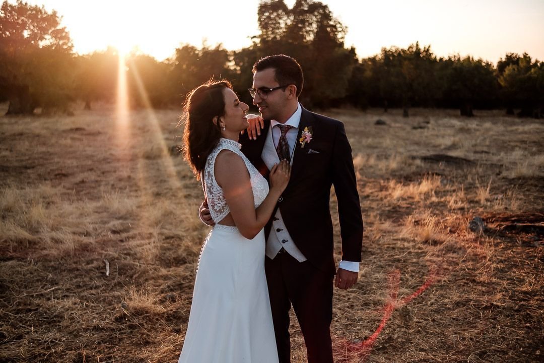 La pareja se mira y sonríe al atardecer durante su postboda en La Granja.
