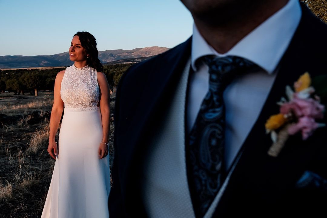 Noelia sonríe al fondo, con el traje y el prendido de Carlos en primer plano.