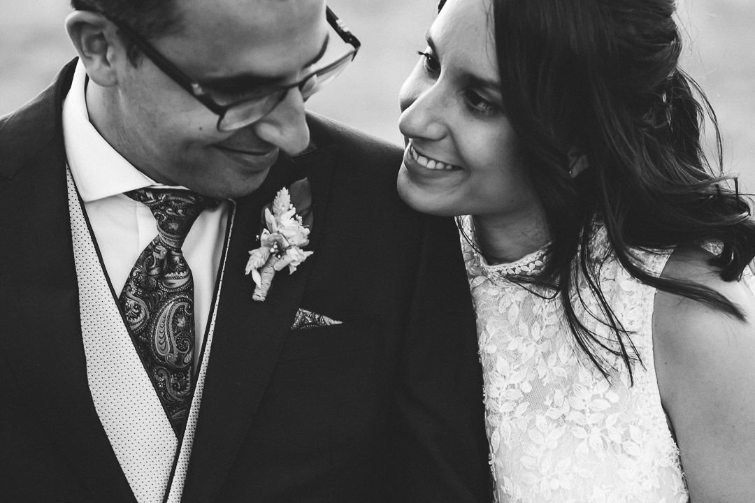 Primer plano en blanco y negro de Noelia y Carlos sonriendo juntos.
