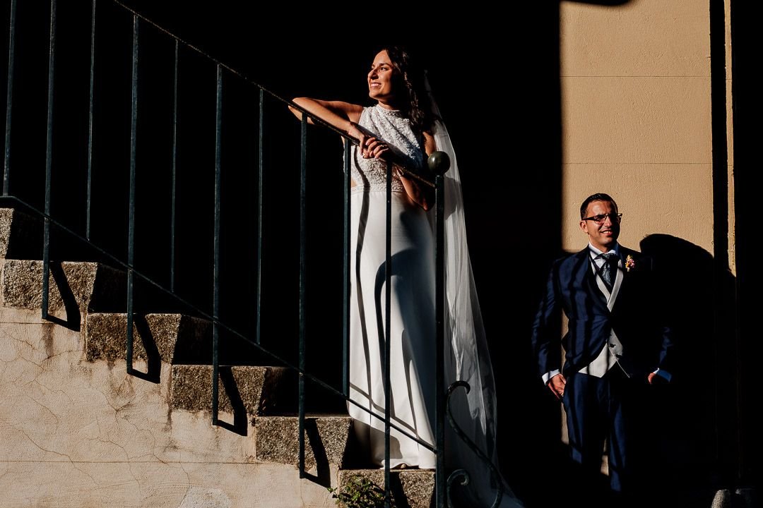 La pareja junto a una barandilla, entre luces y sombras de la fachada.