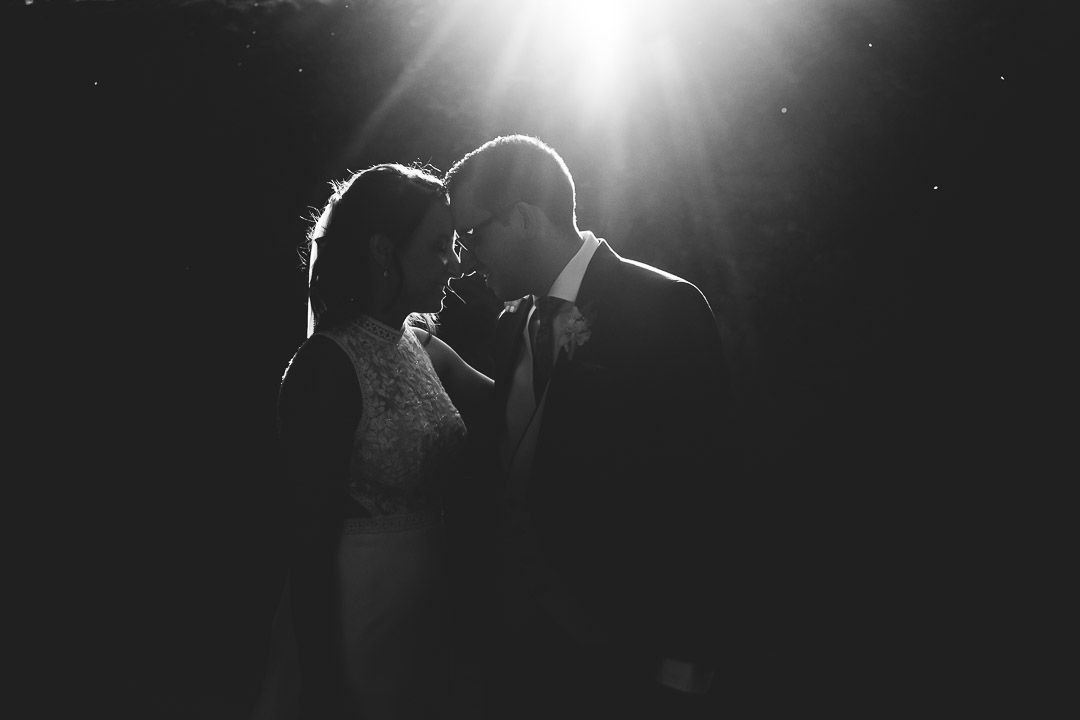 La pareja une sus frentes a contraluz en una fotografía en blanco y negro.