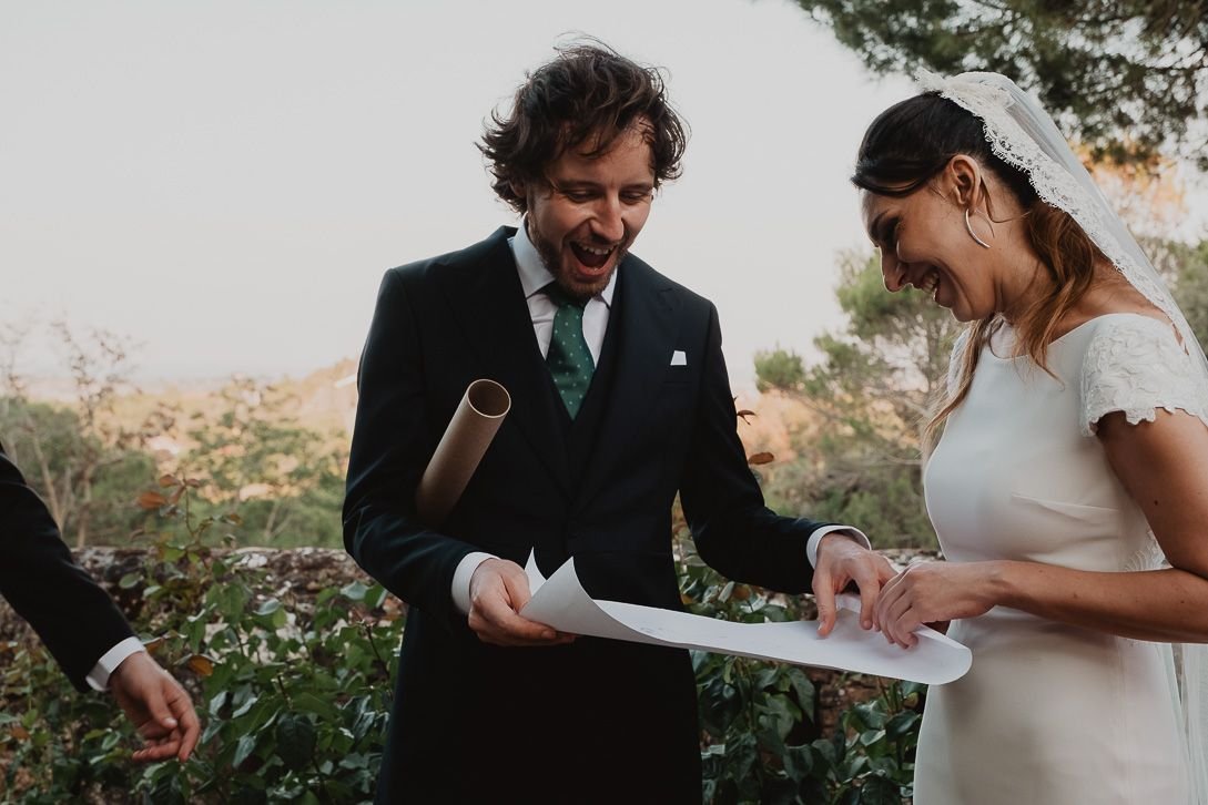 Los novios ríen mientras sostienen un documento tras la ceremonia.