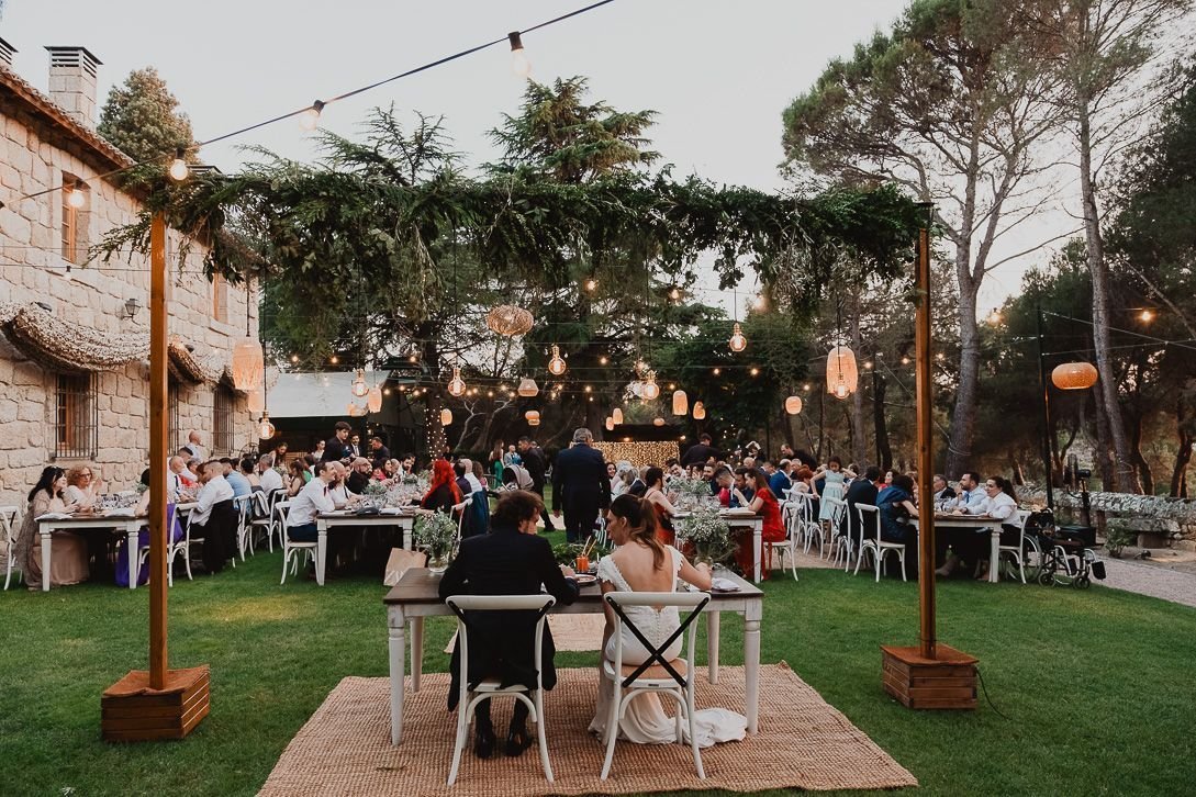 Banquete de boda en El Torreón de Don Jacinto, con mesas y luces en el jardín.