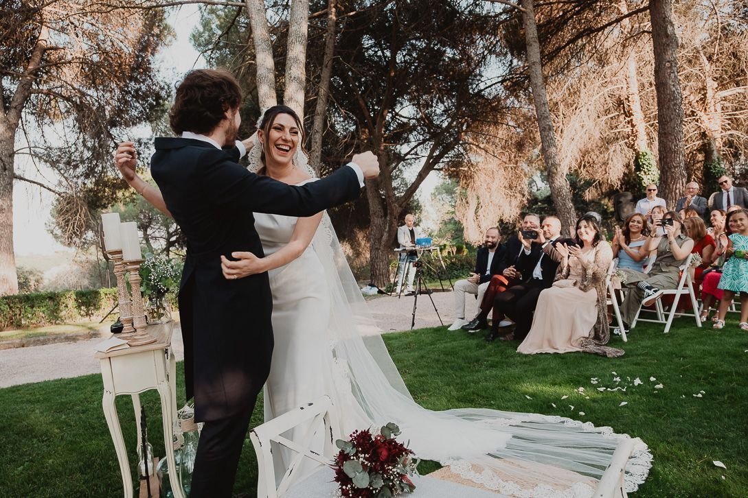 Los novios se abrazan entre risas y aplausos al final de la ceremonia.