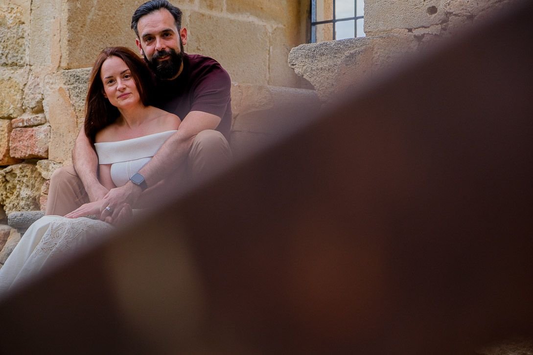 Lara y Javi abrazados en unas escaleras de piedra durante su preboda en Pedraza.