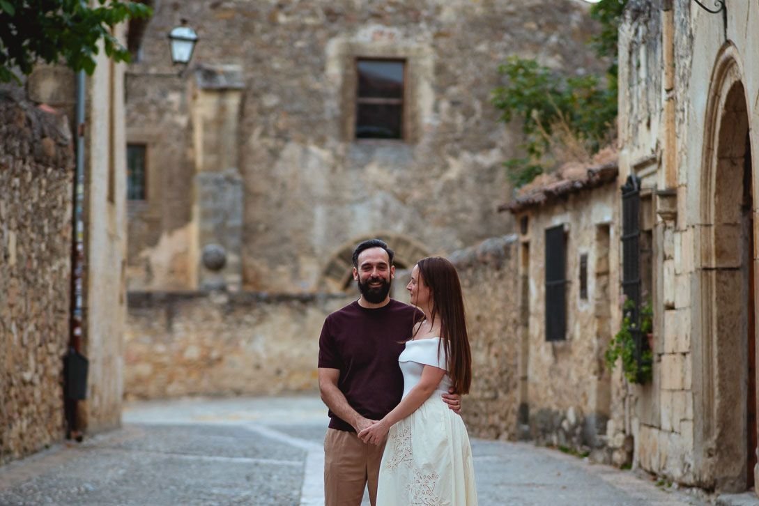 Lara y Javi de la mano en una calle empedrada durante su preboda en Pedraza.
