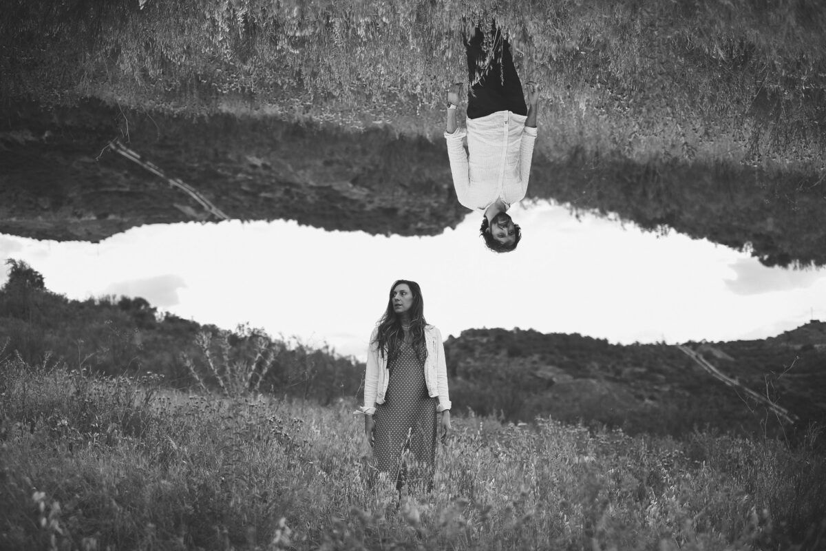 Composición creativa en blanco y negro de Natalia y David en el campo, con la imagen de David invertida.