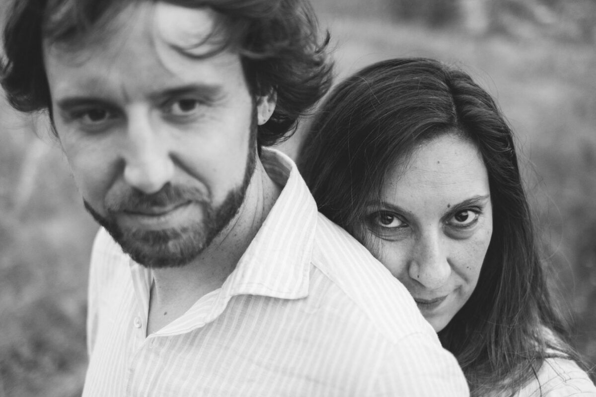 Retrato cercano en blanco y negro de Natalia apoyada en la espalda de David.