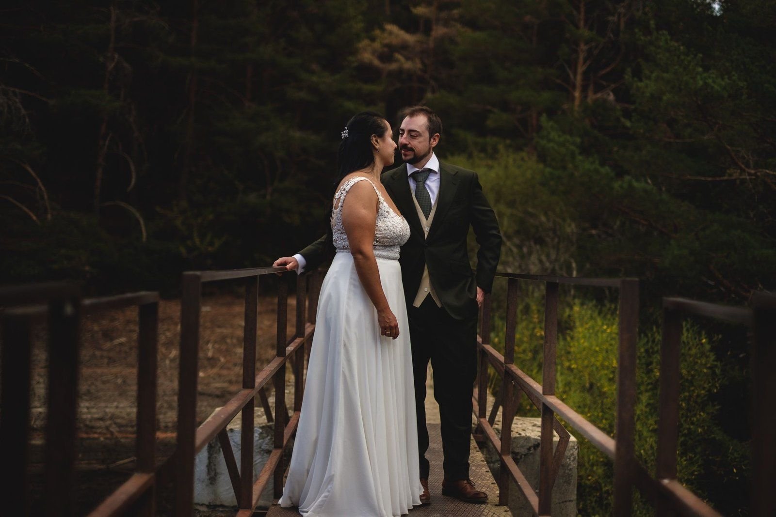 Paola y José juntos en el puente de madera del bosque