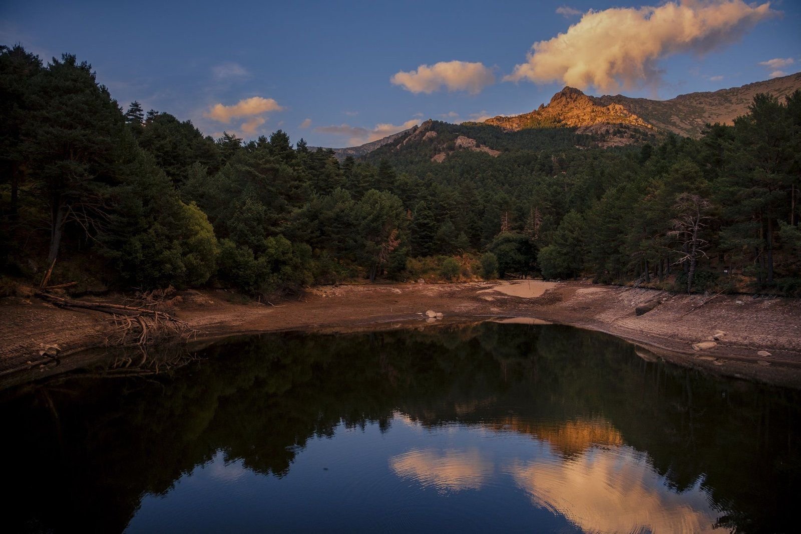 Paisaje de sierra con el bosque reflejado en el agua
